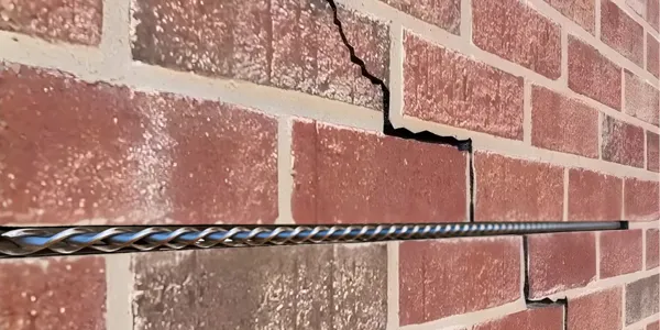 Wall crack repair — a HelicalBar™ stainless steel bar bonded across a stepped crack in a brick wall